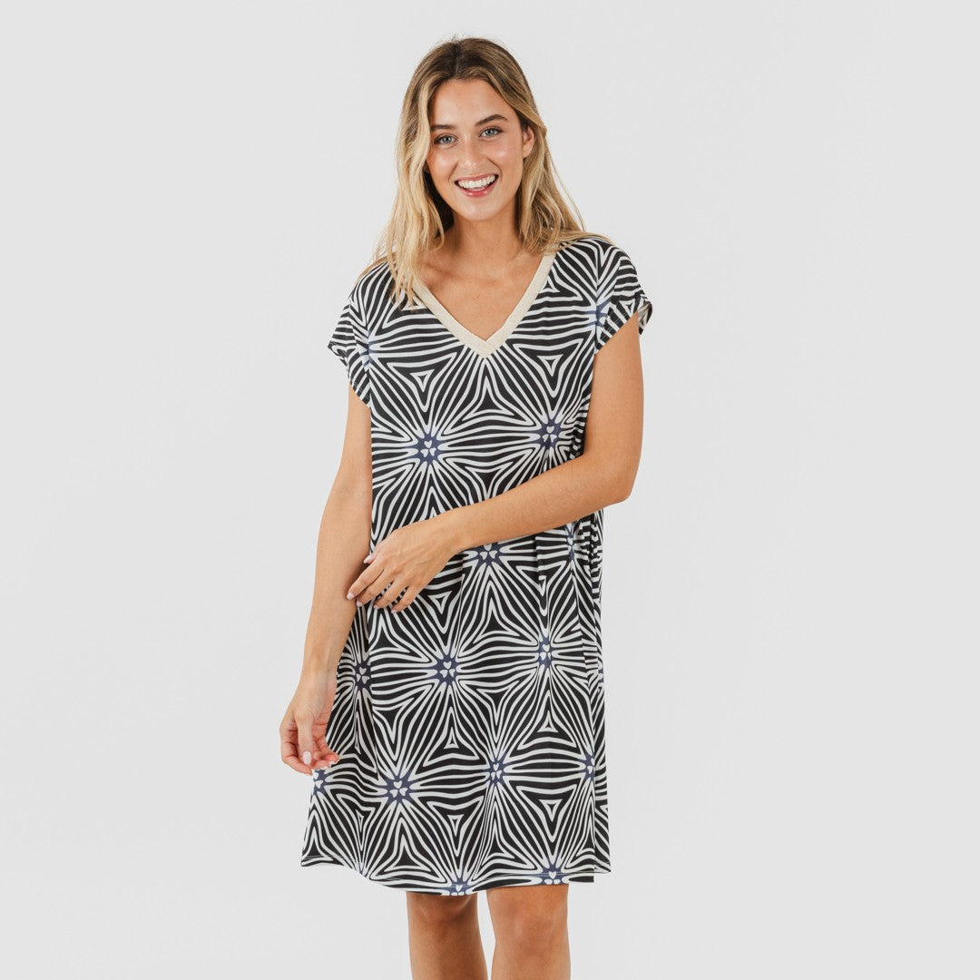 Vestido Naty de mangas curtas e modelagem fluida em tons suaves de bege e preto.