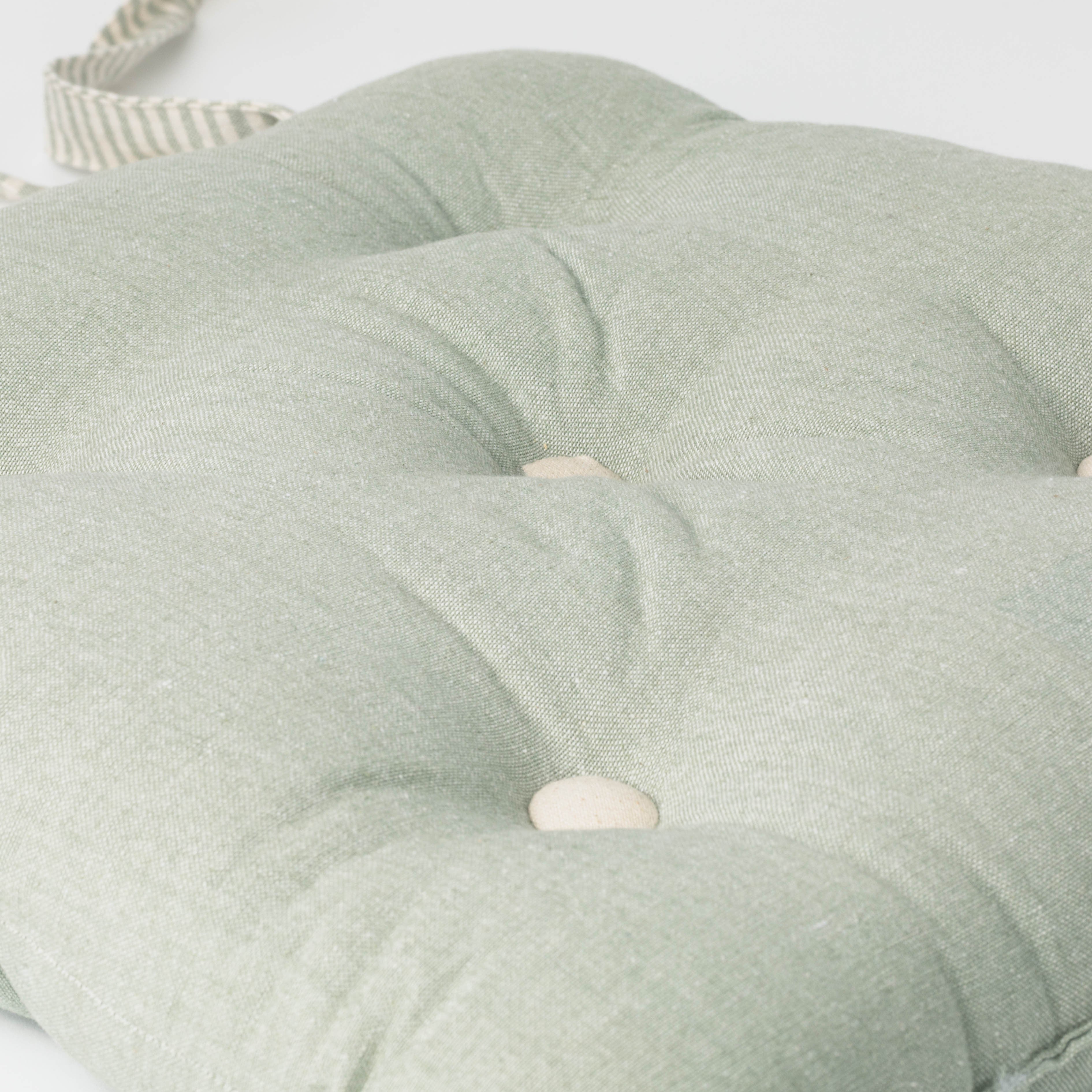 Almofada de algodão simples com botões e ferro de passar.