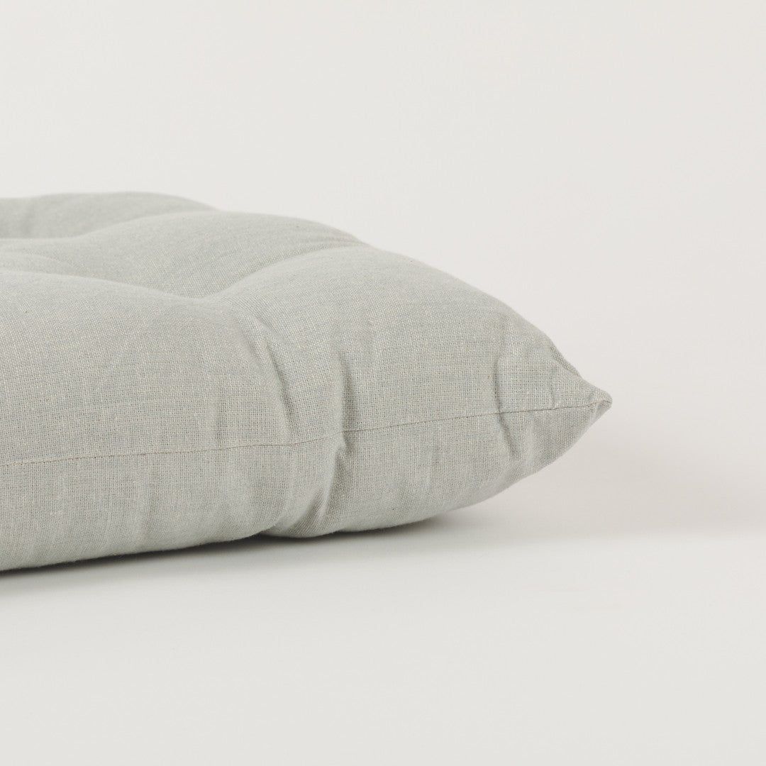 Almofada de algodão simples com botões e ferro de passar.