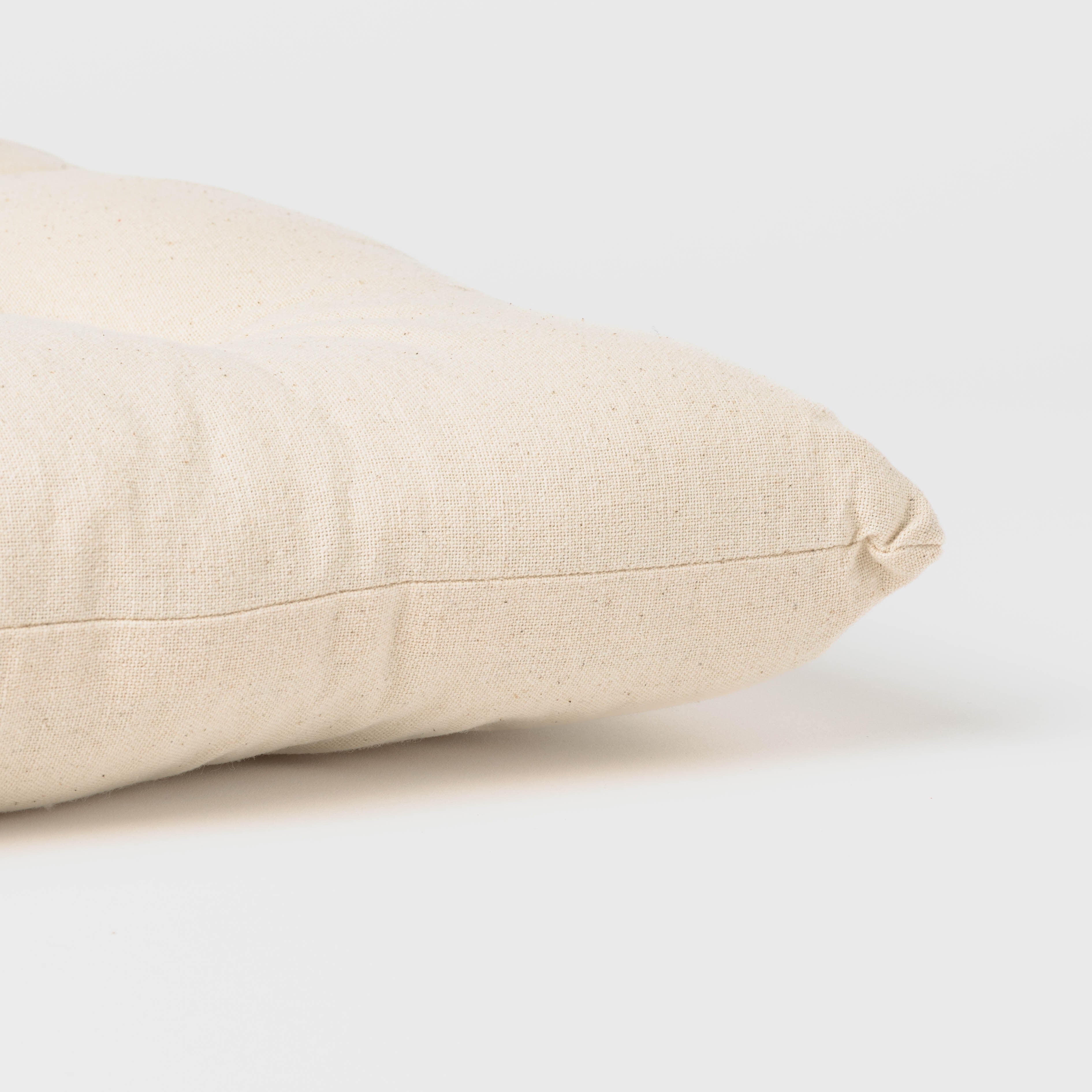 Almofada de algodão simples com botões e ferro de passar.